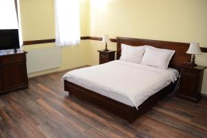 a bedroom with a bed and two lamps and a television at Hotel St. Naum in Ljubaništa