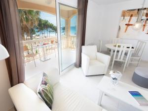 een woonkamer met witte meubels en uitzicht op de oceaan bij Oros de la Mar Bl. III 1A in Canyamel