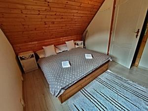 a small bedroom with a bed in a attic at Chata Bačova skala in Liptovský Ján