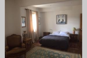 a bedroom with a bed and a chair at Appartement Narada à Limoux in Limoux +8 photos