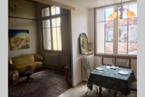 sala de estar con mesa y ventana en Appartement Narada à Limoux, en Limoux