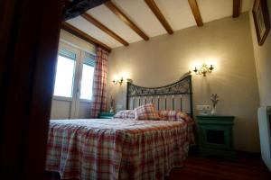 1 dormitorio con 1 cama con manta a cuadros y ventana en Casa Bedia en Gajano