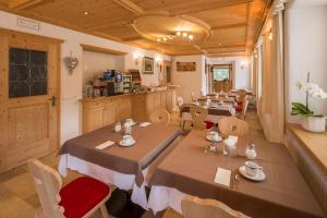 restauracja ze stołami i krzesłami w pokoju w obiekcie Garni Irsara w mieście San Cassiano