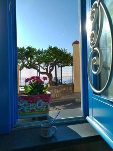 una finestra con una tazza di fiori e una tazza di caffè di Raito Home costa d'Amalfi a Vietri