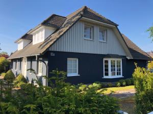 a blue and white house with a roof at Urlaub in Wieck in Wieck