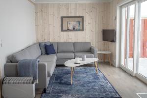 a living room with a couch and a table at Brand new Nappstraumen seaview cabin in Gravdal