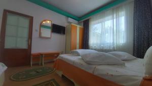 a hotel room with a bed and a window at Ana si Alex in Eforie Nord