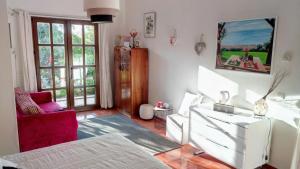 uma sala de estar com uma cama, um sofá e uma cadeira em La Chambre de Ker Briac no Funchal