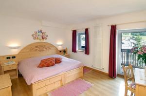 a bedroom with a bed and a desk and a window at Park Hotel Miramonti in San Martino di Castrozza