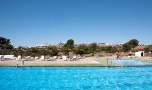 a swimming pool with chairs and umbrellas at Mesón de la Molinera in Arcos de la Frontera