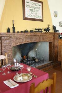 a dining room table with a fire place and a fireplace at Mesón de la Molinera in Arcos de la Frontera