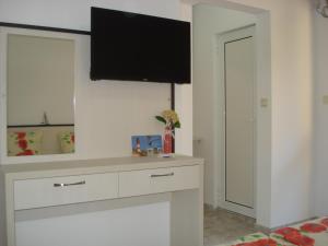 a living room with a tv on a wall at Kupenova Guest House in Sozopol