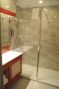 La salle de bains est pourvue d'une douche et d'un lavabo. dans l'établissement Hotel Au Parc des Cigognes, à Kintzheim
