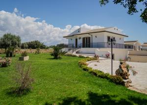 a house with a green lawn in front of it at Casa vacanze IL MANDORLO in Scicli