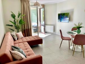 een woonkamer met een bank en een tafel bij Apartament Jantarowe Zacisze Rose in Jantar