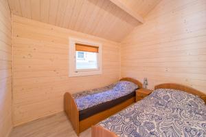 a small room with two beds in a cabin at Domki nad morzem WOJTAS in Wrzosowo