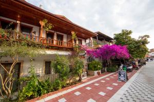 a cobblestone street with a building with pink flowers at MANDALİN AKYAKA in Akyaka