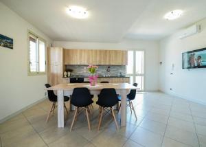 a kitchen with a wooden table and chairs at Casa vacanze IL MANDORLO in Scicli