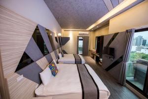 a hotel room with two beds and a tv at Ruo Shui Hotspring Hotel in Jiaoxi