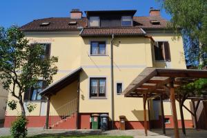 a large yellow building with a brown roof at Arena Apartments in Graz