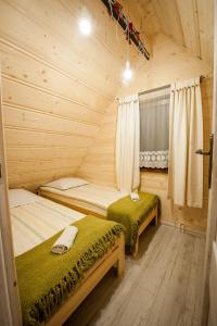 um quarto com 2 camas num chalé de madeira em Domki Narciarskie Zakopane em Zakopane