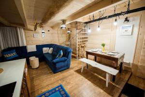 a living room with a blue couch and a table at Domki Narciarskie Zakopane in Zakopane