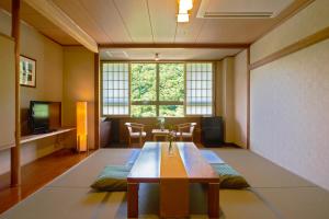 ein Wohnzimmer mit einem Tisch und einem großen Fenster in der Unterkunft Yutoriro Bandai Atami in Koriyama