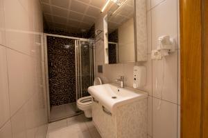 a bathroom with a sink and a shower and a toilet at MANDALİN AKYAKA in Akyaka