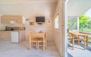 a kitchen and dining area of a tiny house at Domki nad morzem WOJTAS in Wrzosowo