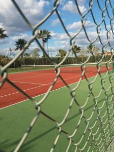 a view of a tennis court through a net at Las Arenas 112 - Atico vista al mar in Isla Canela