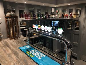 a bar with a row of bottles of alcohol at The Barns Hotel in Cannock