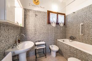 a bathroom with a sink and a tub and a toilet at Tortuga Casa Vacanze in Scarlino
