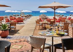a restaurant on the beach with tables and chairs at Hôtel Barrière Le Gray d'Albion in Cannes