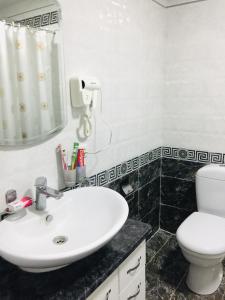 a bathroom with a white sink and a toilet at Cinzano Complex in Samarkand
