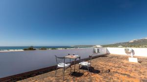 einen Tisch und zwei Stühle auf einer Terrasse mit Strand in der Unterkunft Apartamento Luz C in Bolonia