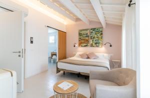 a bedroom with a bed and two chairs and a table at Hotel m - 27 in Es Mercadal