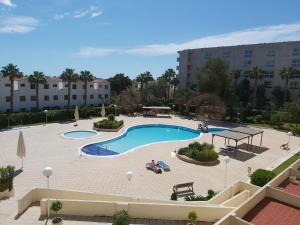 vista su una piscina con tavolo da picnic e sedie di Excelente apartamento a La Pineda