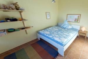 a small bedroom with a blue bed in a room at Ferienhaus Bettina in Dornumersiel