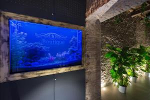 a large blue aquarium in a room with plants at Le Boutique Luxury Rooms diffused in Historic Center in Fiumicino