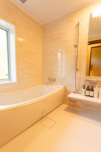 YOISAMA Sunset Beach House في جزيرة إيشيغاكي: حمام مع حوض استحمام ونافذة