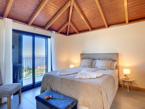 a bedroom with a large bed and a large window at Casa da Felicidade by LovelyStay in Prazeres