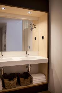 a bathroom with a sink and a mirror at Toc Hostel Sevilla in Seville