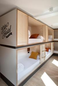 a bedroom with a white bed and white walls at Toc Hostel Sevilla in Seville