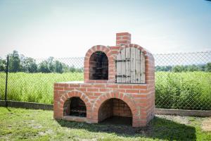 a brick oven in a field next to a fence at Apartamenty Pawełek in Zator +92 photos