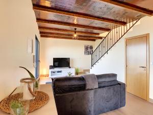 a living room with a leather couch and a tv at Casa da Felicidade by LovelyStay in Prazeres