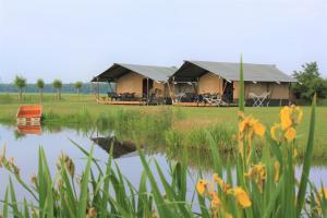a luxury tent next to a body of water at Safaritenten 'Woody' in Kuinre