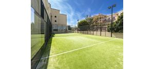 イスラ・デル・モラルにあるPlaya Marina by Ĥの緑の芝生が敷かれたテニスコート