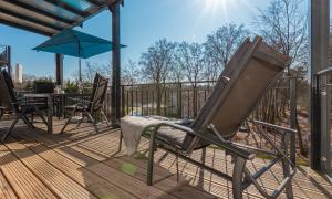 a chair on a deck with a table and an umbrella at Ferienwohnung Vergissmeinnicht in Ostseebad Sellin