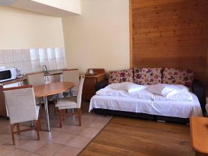 1 dormitorio con cama, mesa y cocina en Azuga Ski & Bike Resort, en Azuga