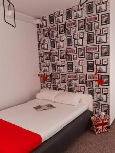 a bed in a room with a wall of pictures at Pastel Guest Rooms in Warsaw